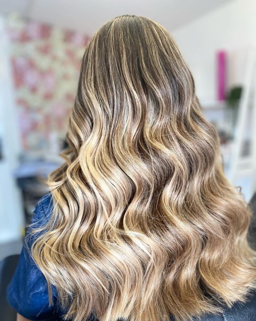Long blonde balayage with soft, flowing waves